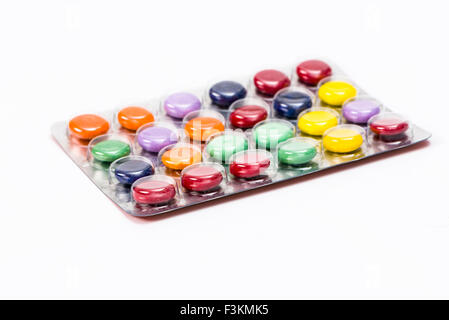Una filmina con colorati medicina compresse, visualizzata su un tavolo bianco Foto Stock