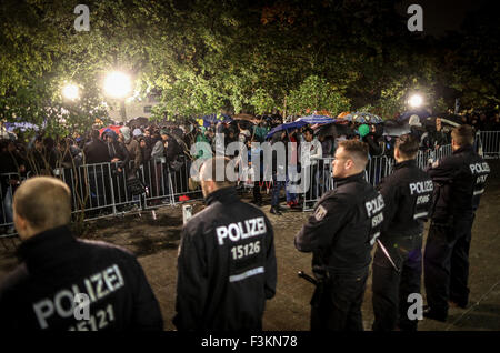 Berlino, Germania. 09oct, 2015. Gli ufficiali di polizia fissare i motivi di carica dello stato di salute e il benessere degli animali (LaGeSo) come egli rifugiati attendere per la registrazione e l'assegnazione di un posto per dormire nei locali della a Berlino, Germania, 09 ottobre 2015. Foto: Kay Nietfeld/dpa/Alamy Live News Foto Stock