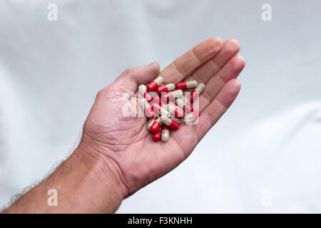 Molti rossi e trasparente capsulas medica, riempiti con la medicina giallo visualizzato su un lato Foto Stock