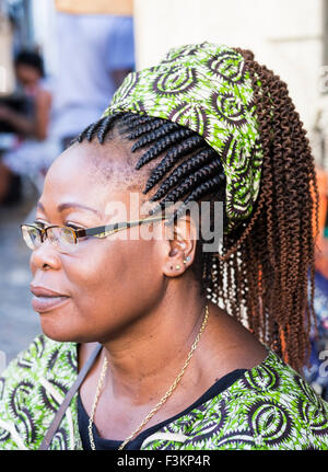 Fornitore di donna con capelli intrecciati, green stampa abito e velo presso la piazza del mercato, Greenpoint, Cape Town, Sud Africa Foto Stock