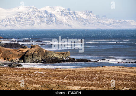 A est di fiordi in Islanda con vulcani innevati in background Foto Stock