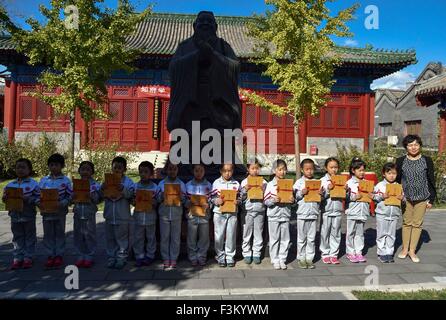 Pechino, Cina. 9 Ott, 2015. Gli alunni di Fuxue Hutong Scuola Primaria ricevere libri durante una cerimonia di ingresso presso la Sala Dacheng del tempio confuciano di Pechino, capitale della Cina, il 9 ottobre, 2015. Un ingresso tradizionale cerimonia si è svolta presso la scuola di venerdì. Fondata nel 1368, Fuxue Hutong Primary School è una scuola moderna caratteristica della cultura tradizionale cinese ed è anche una scuola con Tempio confuciano conservati fin dai tempi antichi. © Luo Xiaoguang/Xinhua/Alamy Live News Foto Stock