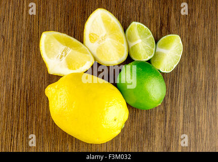 Colpo di overhead di vibranti mature limes verde e giallo dei limoni, tagliare e intera Foto Stock