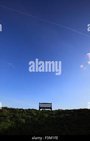 Una panca in legno e una grande blu cielo chiaro. Foto Stock