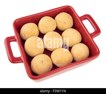 Laddu indiano (ladoo) dessert dolci disposti in un quadrato rosso piatto isolato su uno sfondo bianco Foto Stock