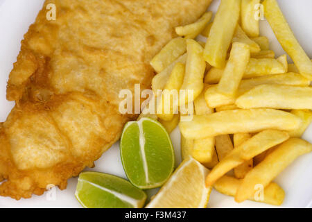 Vista aerea del tradizionale pesce e patatine pasto con chip, martoriata pesce e limone e spicchi di lime Foto Stock