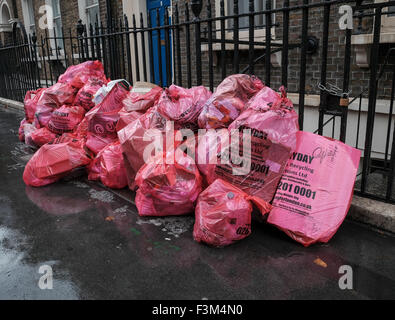 Riciclare la spazzatura per le strade di Londra in sacchi di colore rosa Foto Stock