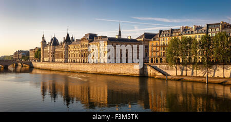 Senna riva destra incandescente con la luce del mattino mostrare la Conciergerie, Quai de l'Horloge sulla Ile de la Cite. Francia Foto Stock