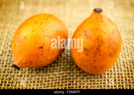 Rustico tela di Hesse sfondo con frutta achacha Foto Stock