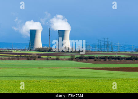 Il nucleare di Grafenrheinfeld powerplant è di vaporizzazione delle torri di raffreddamento contro le nuvole scure, situato in landsc agricoli Foto Stock