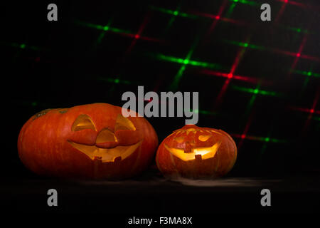 Due zucche di Halloween fiocchi di fumo/sfondo nero con effetti laser Foto Stock