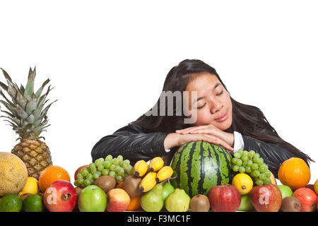 Molti frutti impilati insieme e carina ragazza Foto Stock