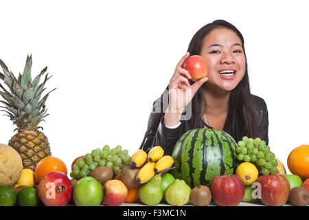 Molti frutti impilati insieme e carina ragazza Foto Stock