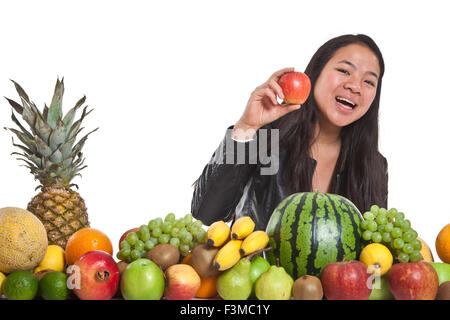 Molti frutti impilati insieme e carina ragazza Foto Stock