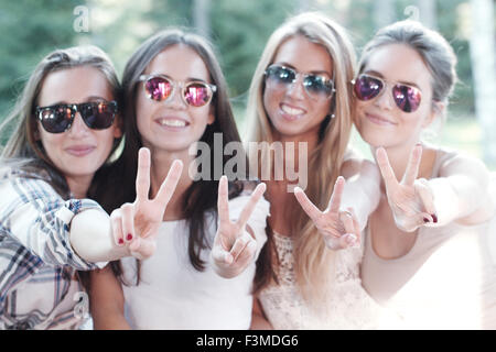 Sorridenti fidanzate che mostra una mano v segno Foto Stock