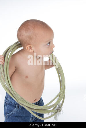 Baby boy giocando e cercando di capire il lazo in studio. Foto Stock