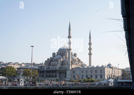 I pescatori pesca con aste dal ponte Galata con la nuova moschea in background, Istanbul, Turchia. Foto Stock