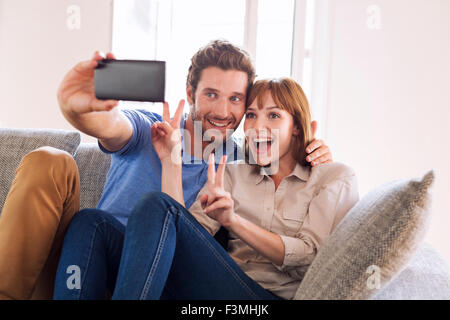 Happy Fun giovane prendendo un selfie con un telefono cellulare. La felicità, godimento Foto Stock