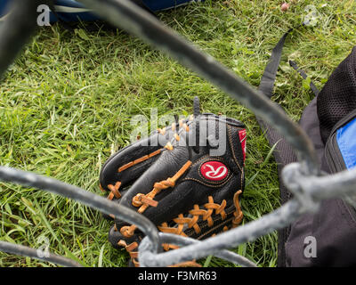 Guanto da baseball sul terreno come visto attraverso una catena collegamento recinto. Foto Stock