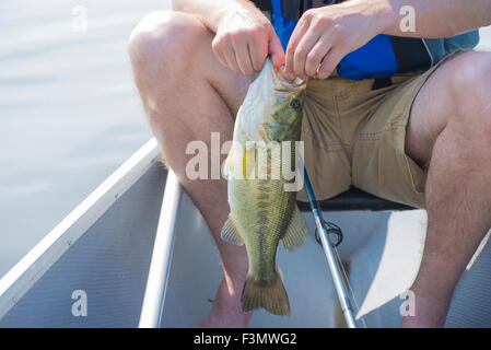 Pescatore con appena pescato tamburo di acqua dolce pesci nel lago Erie, Ontario, Canada. Foto Stock