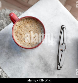 Il caffè nella tazza rossa su una tavola di marmo, dal di sopra Foto Stock