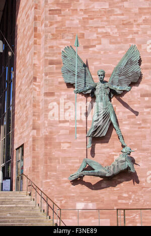 Statua in bronzo di San Michele conquistando il diavolo da Jacob Epstein, montato su una parete accanto all'ingresso del Coventry Cathedral Foto Stock