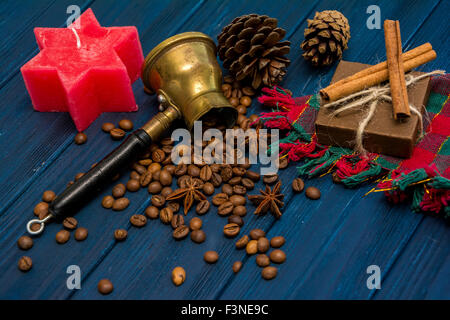 I chicchi di caffè, anice, cannella, Turk, presente casella e coni blu scuro dello sfondo di legno. Sfondo di natale Foto Stock