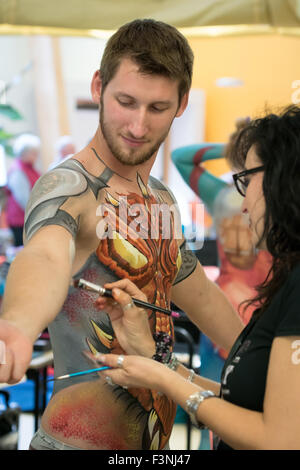 Eden Project, Bodelva, Cornwall, Regno Unito. 10 ottobre, 2015. La pittura è stato avviato per il corpo corpo di fabbrica concorso di pittura. Karen Harvey artista e Luca modello Herman vedere il body painting artisti provenienti da tutto il mondo gareggiano per produrre le più spettacolari creazioni, nella quinta relazione annuale internazionale BodyFactory Body Painting Festival. Credito: sean gee/Alamy Live News Foto Stock