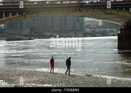 Londra, UK, 8 ottobre 2015, due persone a piedi lungo la foreshore del Tamigi. Foto Stock