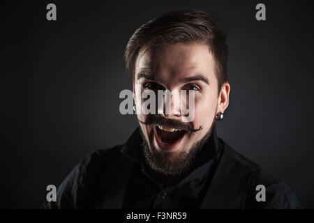 Bel ragazzo brutale con la barba su sfondo scuro Foto Stock
