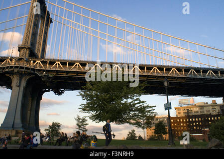 Un fotografo sotto il ponte di Manhattan Bridge. Questo ponte ha sempre vissuto in ombra del suo illustre fratello più anziano, t Foto Stock