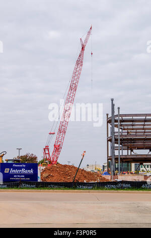 Una gru sorge accanto al quadro in acciaio per un edificio commerciale nel processo di costruzione nella città di Oklahoma, Oklahoma, Stati Uniti d'America. Foto Stock