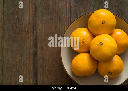 Vassoio di frutta oin legno scuro tabella Foto Stock