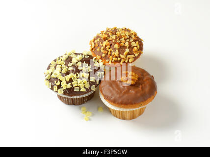 Tre muffin al cioccolato su sfondo bianco Foto Stock