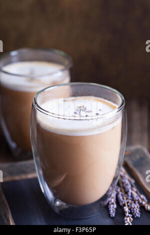 Latte caldo in grande doppia parete a vetri con lavanda essiccata Foto Stock