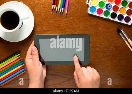 Tablet e gli strumenti di disegno sul tavolo e le mani Foto Stock