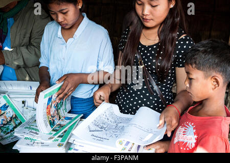 Un curioso ragazzo in cerca di nuovi libri di testo in Cambogia, in Asia. Foto Stock