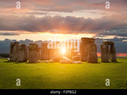 Il sole che tramonta sulla Stonehenge, Wiltshire, Inghilterra. Foto Stock