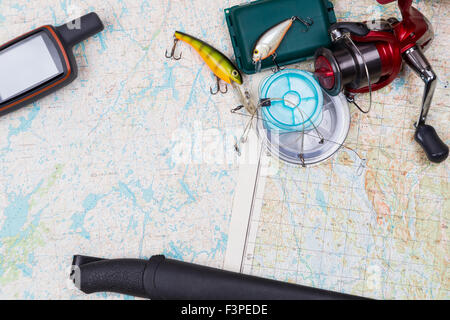 Preparazione in viaggio di pesca con la pesca affronta e gps navigator su sfondo mappa Foto Stock