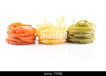 Tre colori nido di rotolo di pasta su uno sfondo bianco Foto Stock