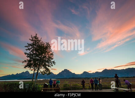 Il turista a godere il tramonto vista dal cortile del famoso & storica Jackson Lake Lodge; il Parco Nazionale del Grand Teton; Teton gamma Foto Stock