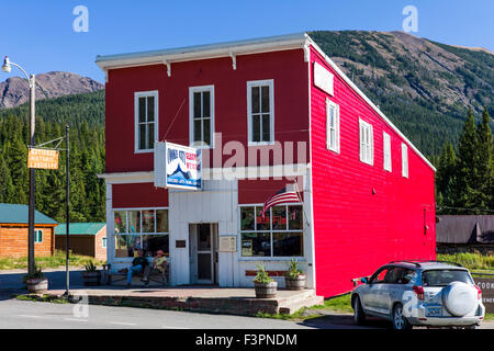 Vista esterna del rosso brillante metallo pressato schierandosi su Cooke City General Store; Cooke City; Montana; USA Foto Stock