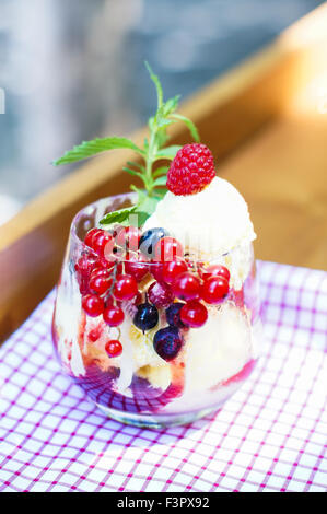 Vanila gelato con frutta di stagione e menta in vetro per esterno Foto Stock