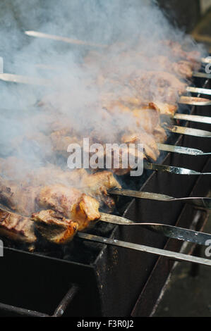 La carne fritta. Georgian mtsvadi (spiedini) preparazione. Fumatori spiedini. Il cibo gustoso. Foto Stock