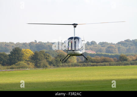 Havering elicottero basso sopra Wolverhampton Halfpenny Green Airport. Regno Unito Foto Stock