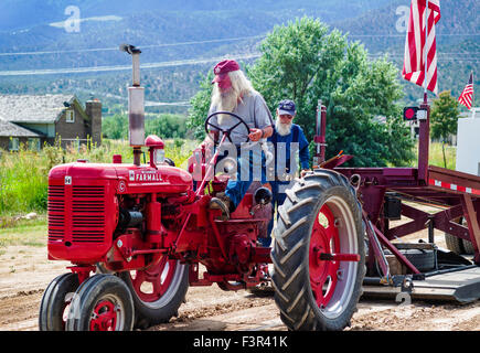 Il Rancher guidando il trattore di antiquariato, Antico trattore tirare Evento, Chaffee County Fair & Rodeo, Salida, Colorado, STATI UNITI D'AMERICA Foto Stock
