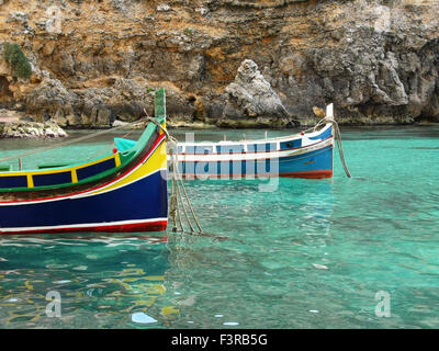 Colorato Fisherman's eyed boat chiamato 'Iuzzu" tipici di Malta ancorata in un acqua cristallina Foto Stock