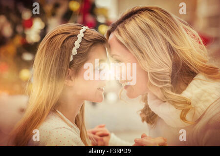 Festive madre e figlia accanto all albero di natale Foto Stock
