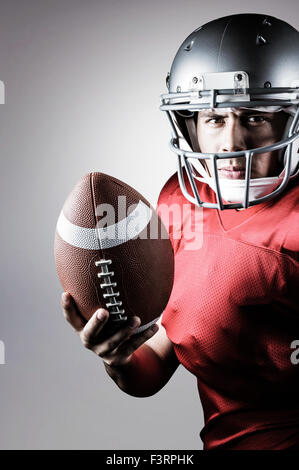 Immagine composita del ritratto di determinato giocatore di football americano con sfera Foto Stock