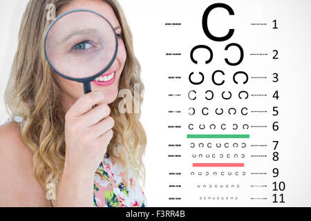 Immagine composita della donna sorridente tenendo la lente di ingrandimento Foto Stock